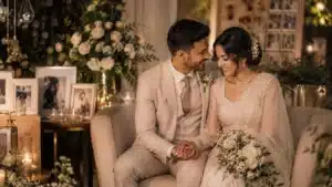 How to make your wedding feel personal | Sri Lankan bride and groom sharing an intimate wedding moment while seated together in a warmly lit venue surrounded by candles, floral décor, framed memories, and personalised wedding details.